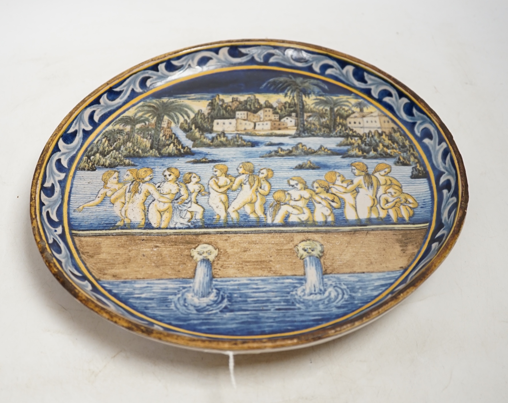 An 18th / 19th century Castelli maiolica plate, decorated with nude females bathing, 28.5cm diameter. Condition - fair to good